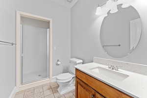 Bathroom with toilet, baseboards, a shower stall, and vanity