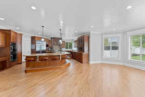 Kitchen featuring recessed lighting, plenty of natural light, stainless steel appliances, and a spacious island