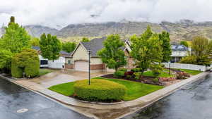 View of front of house featuring fence, an attached garage, brick siding, a mountain view, and driveway