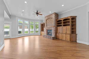 Unfurnished living room with crown molding, a ceiling fan, recessed lighting, and light wood-style floors