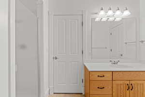 Full bath with vanity, tile patterned floors, and a stall shower