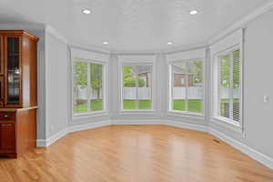 Interior space featuring light wood-style floors, ornamental molding, baseboards, and visible vents