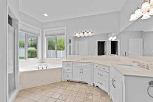 Bathroom featuring double vanity, recessed lighting, a sink, and a bath