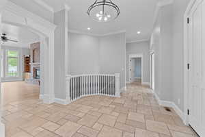 Hallway with visible vents, baseboards, an upstairs landing, recessed lighting, and stone tile floors
