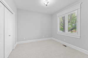 Unfurnished bedroom featuring a closet, baseboards, carpet flooring, and visible vents
