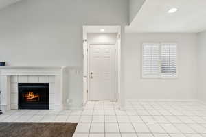 Tiled foyer with baseboards, recessed lighting, and a fireplace