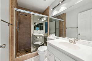 Full bathroom featuring vanity, tile patterned flooring, a stall shower, and toilet