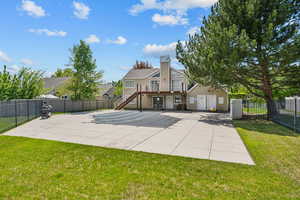 Back of property featuring a yard, a chimney, fence private yard, and stairs