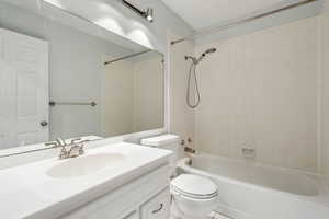 Full bathroom featuring toilet,  shower combination, and vanity
