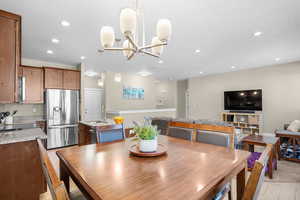 Dining room with recessed lighting, an inviting chandelier, and light wood-style floors