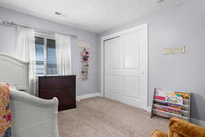 Bedroom with baseboards, visible vents, carpet, and a closet