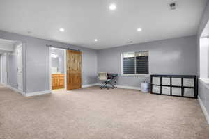 Unfurnished office featuring visible vents, a barn door, and carpet