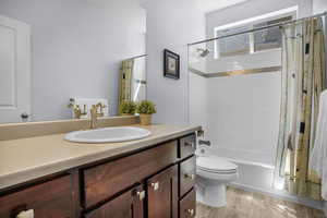 Full bath with vanity, toilet, and shower / tub combo with curtain