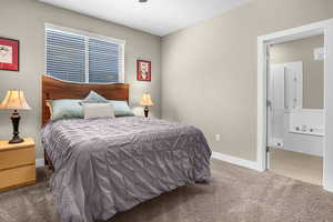 Bedroom featuring carpet floors, baseboards, and connected bathroom