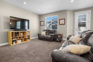 Carpeted living room with baseboards, recessed lighting, and a textured ceiling