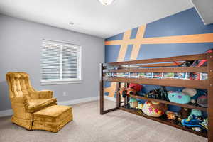 Carpeted bedroom featuring baseboards, lofted ceiling, and visible vents