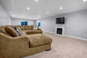 Living area featuring recessed lighting, baseboards, and light carpet