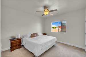 Bedroom with baseboards, ceiling fan, light carpet, and visible vents