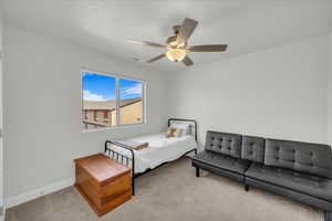 Carpeted bedroom with visible vents, baseboards, and ceiling fan