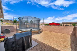 View of yard with central air condition unit, a trampoline, and a fenced backyard