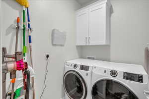 Laundry room with cabinet space and washer and clothes dryer
