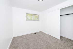 Unfurnished bedroom featuring a closet, carpet, and baseboards