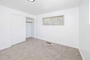 Unfurnished bedroom featuring baseboards, visible vents, carpet, and a closet
