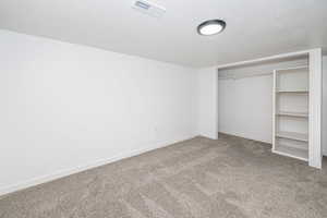 Unfurnished bedroom featuring a closet, baseboards, carpet flooring, and visible vents
