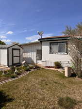 Exterior space with a lawn, an outdoor structure, and a shed