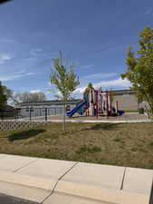 Community play area with a lawn and fence