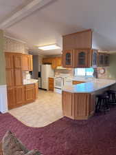 Kitchen with decorative backsplash, a peninsula, white appliances, glass insert cabinets, and light countertops