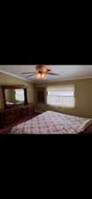 Bedroom with ceiling fan and ornamental molding