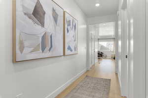 Hall with recessed lighting, baseboards, and light wood finished floors