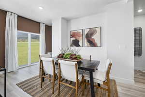 Dining area with recessed lighting, a heating unit, a wealth of natural light, and light wood-style flooring