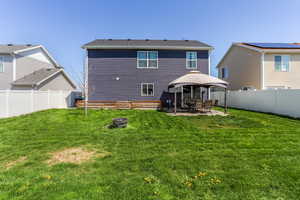 Rear view of property featuring a patio, an outdoor fire pit, a yard, and a gazebo