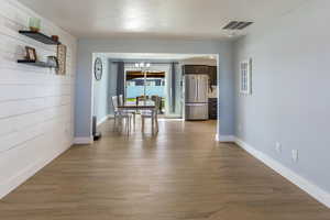 Dining area with baseboards, visible vents, an inviting chandelier, and wood finished floors