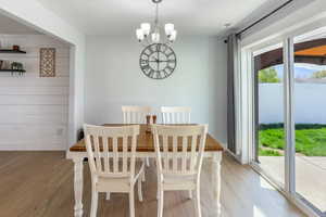 Dining space with plenty of natural light, light wood-style floors, and a chandelier