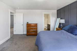 Bedroom featuring baseboards, carpet, and ensuite bath