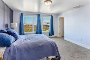 Carpeted bedroom featuring visible vents and baseboards