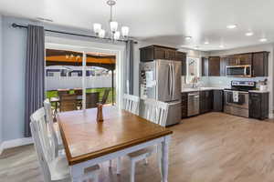 Dining space with visible vents, light wood-style floors, baseboards, recessed lighting, and a chandelier