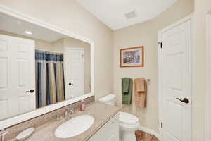 Bathroom with vanity, toilet, and visible vents