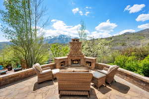 View of patio / terrace with a mountain view and an outdoor living space with a fireplace