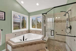 Full bathroom with recessed lighting, vaulted ceiling, a shower stall, and a garden tub