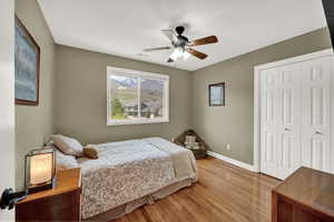Bedroom featuring visible vents, a closet, baseboards, a ceiling fan, and light wood finished floors