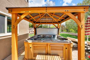 View of patio with a gazebo and a hot tub