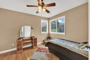 Bedroom with visible vents, a ceiling fan, baseboards, and light wood-style floors