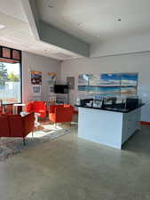 Living room with recessed lighting, baseboards, concrete floors, and electric panel