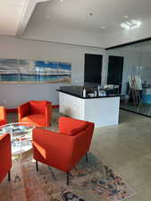 Living area with recessed lighting, baseboards, and concrete floors