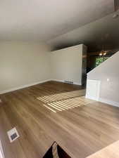 Interior space with a ceiling fan, baseboards, visible vents, and wood finished floors