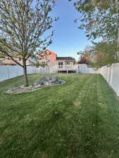 View of yard featuring a fenced backyard, an outbuilding, a deck, and a storage shed